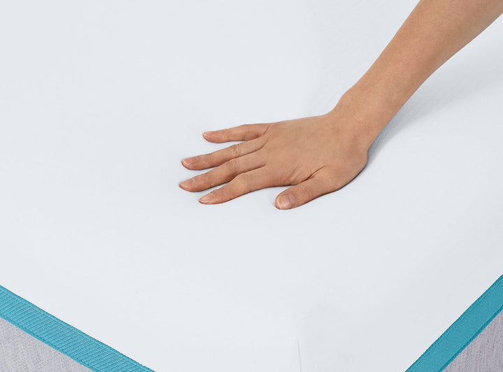 Hand pressing down on the soft Helix Sunset Mattress