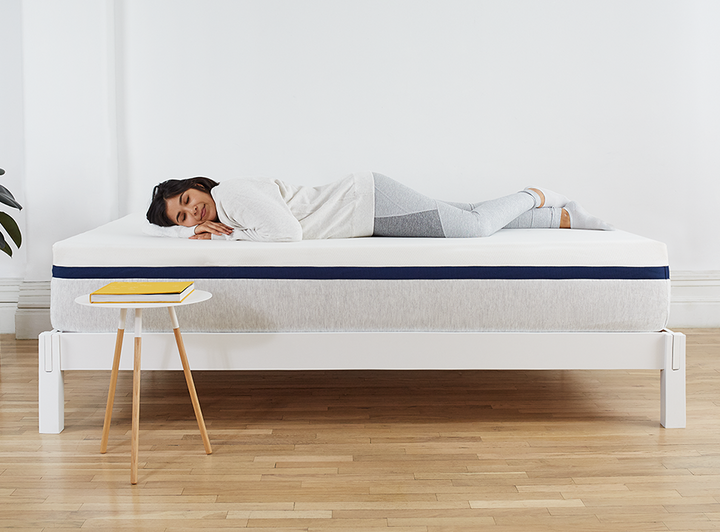 Woman lying on Helix Mattress on Helix White Wood Frame